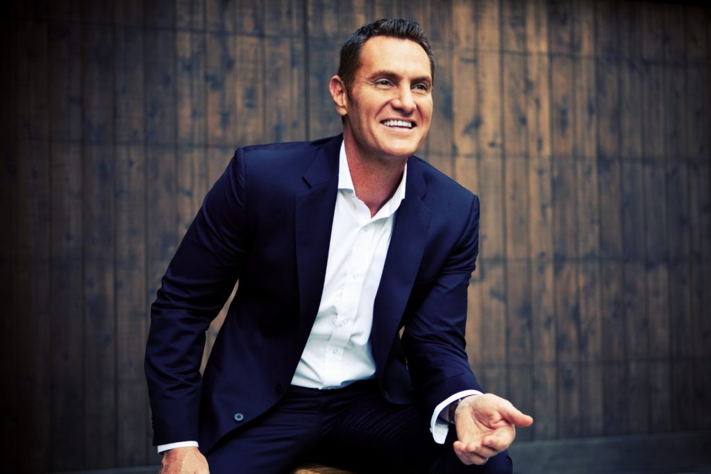 Darren Hardy, Creator of Insane Productivity, in Front of a Wooden Background