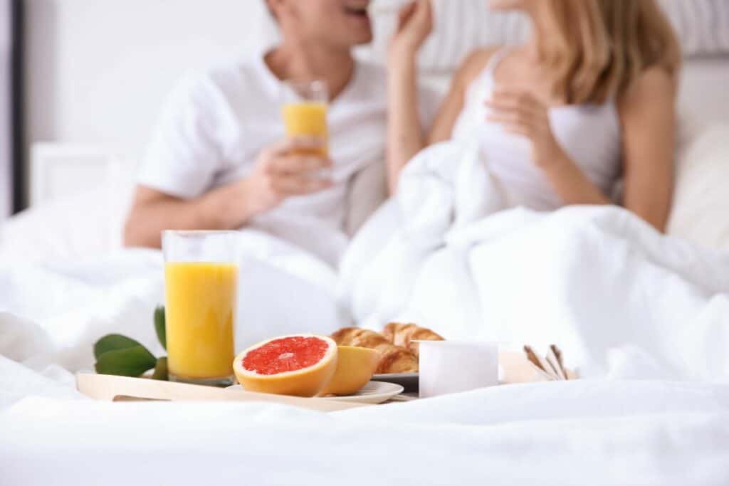 Breakfast in Bed with couple in the background