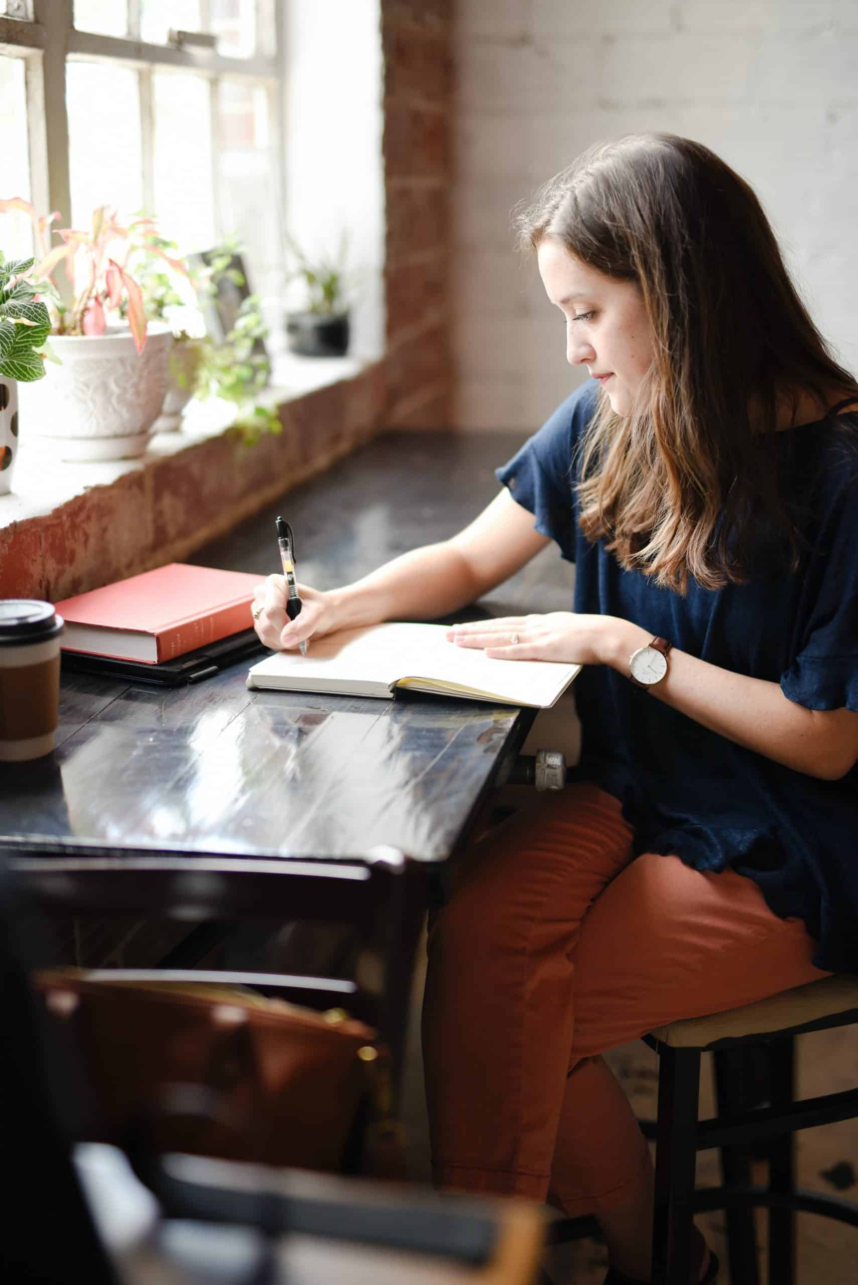 woman sitting at a desk journaling