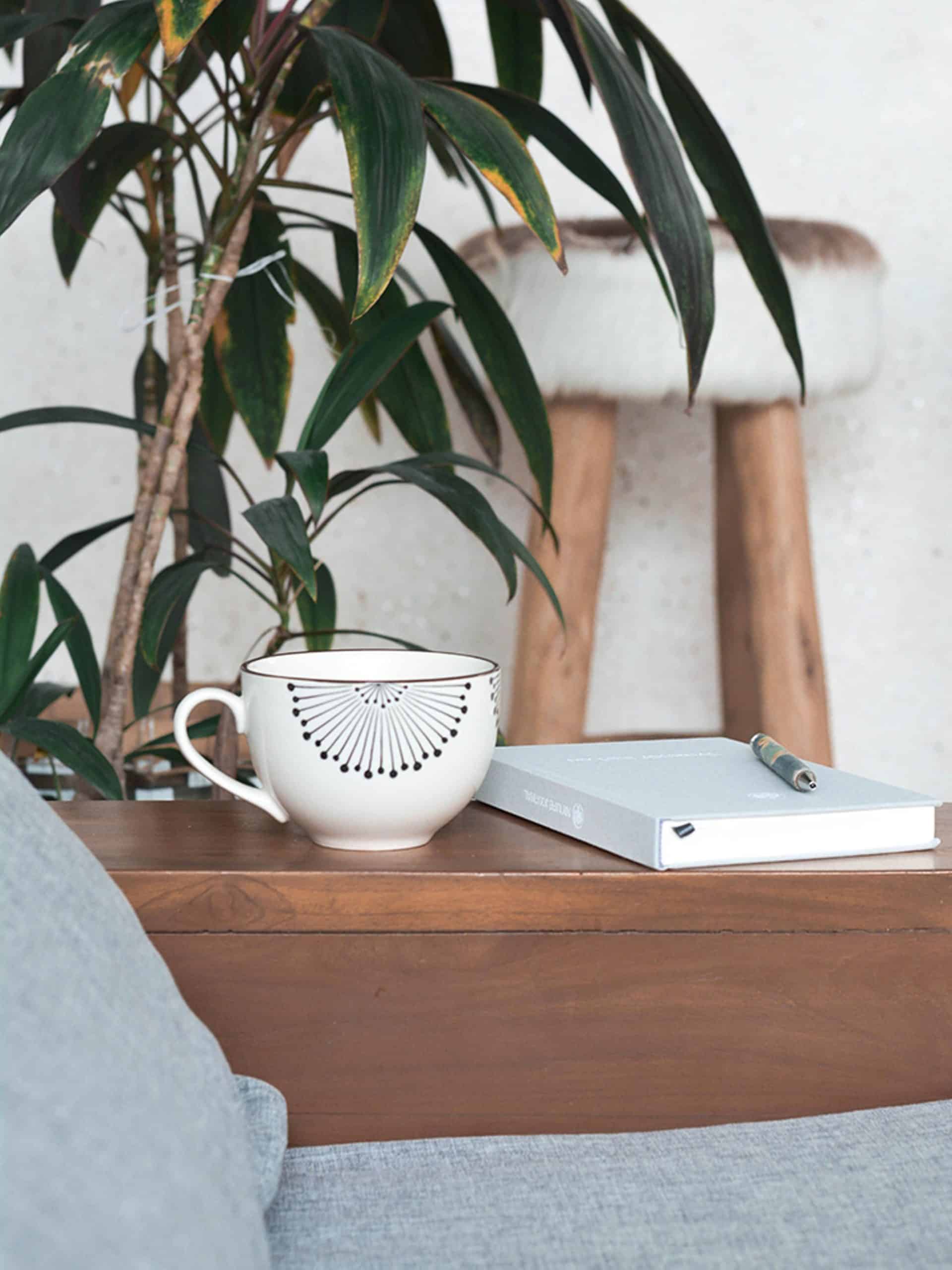 journal next to coffee cup on a side table