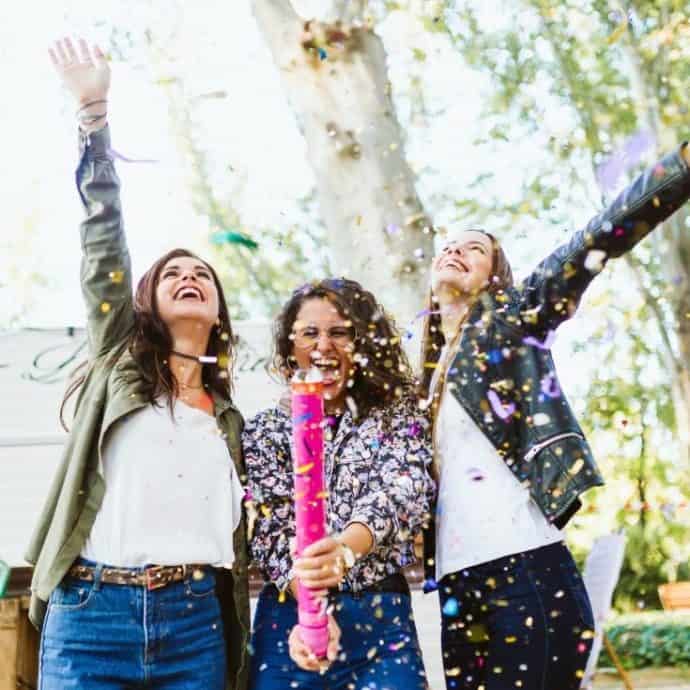 3 girls popping confetti