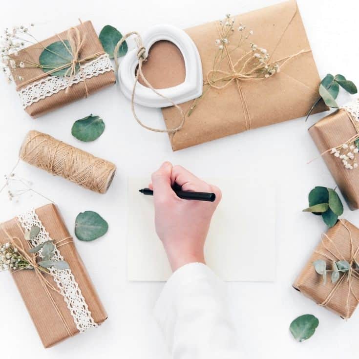 individually wrapped gifts and person starting to write a letter