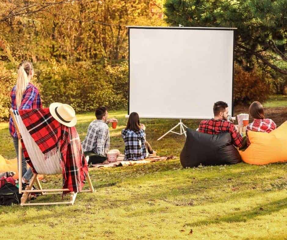 young people getting ready to watch a movie outdoors