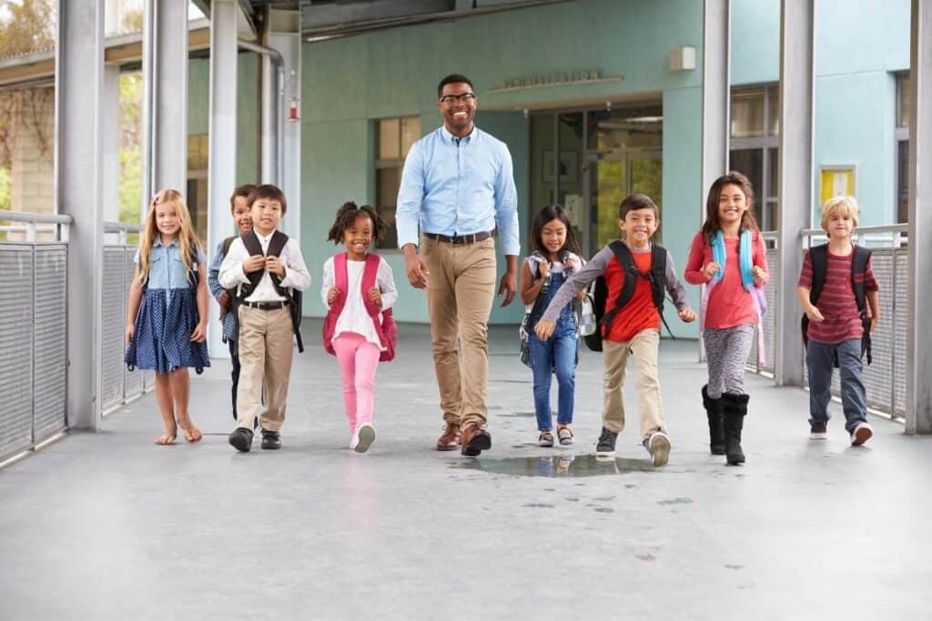 male teacher with his class of young students