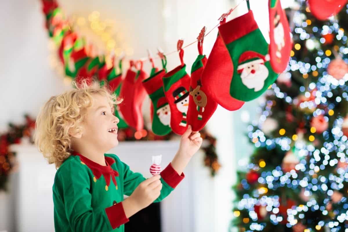 little boy reaching for a small bag on an advent calendar