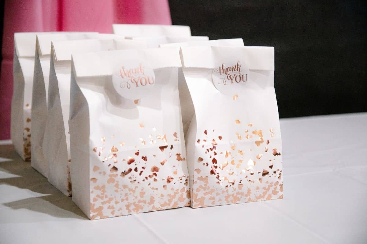 sweet 16 party favor ideas in a white gift bag with rose gold detailing and a sticker that says Thank You