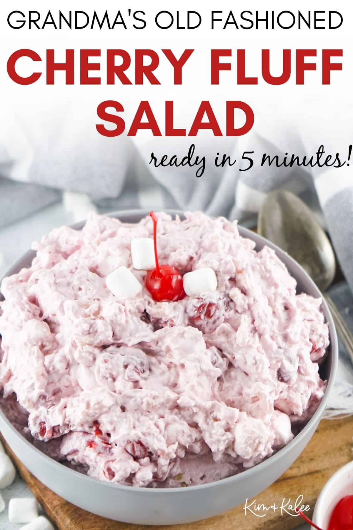 the cherry dump salad in a bowl topped with a cherry -- text overlay on the top "Grandma's Old Fashioned Cherry Fluff Salad"