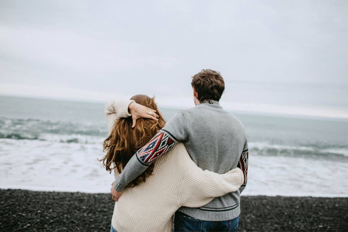 couple hugging looking at the ocean