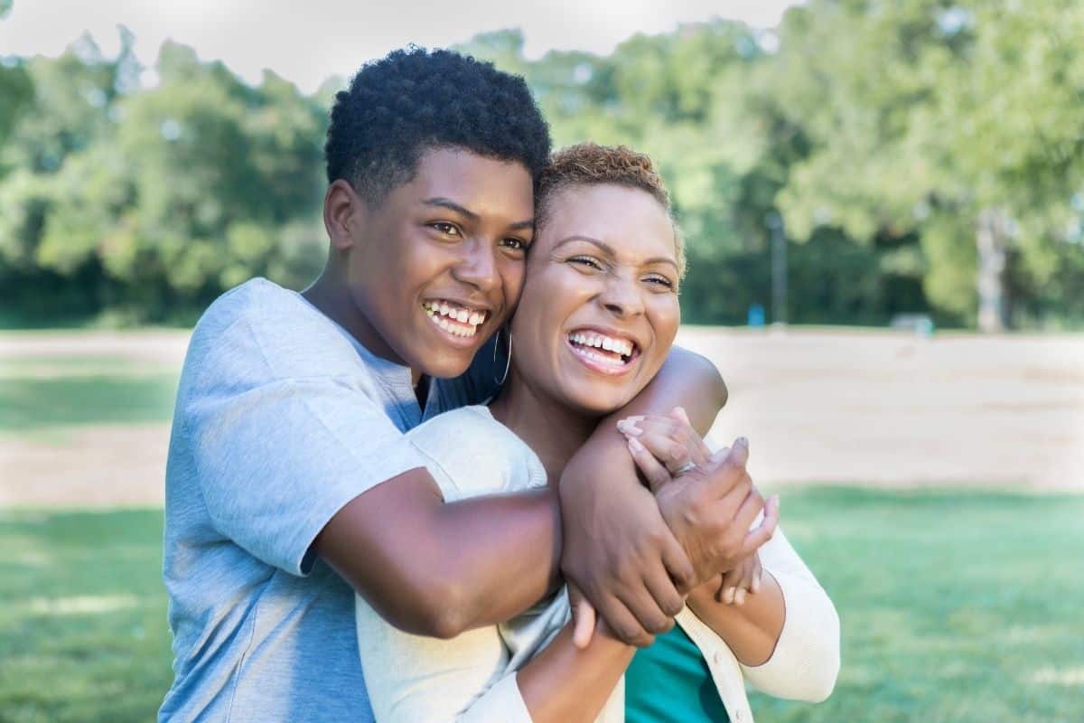 mom and teenage son hugging