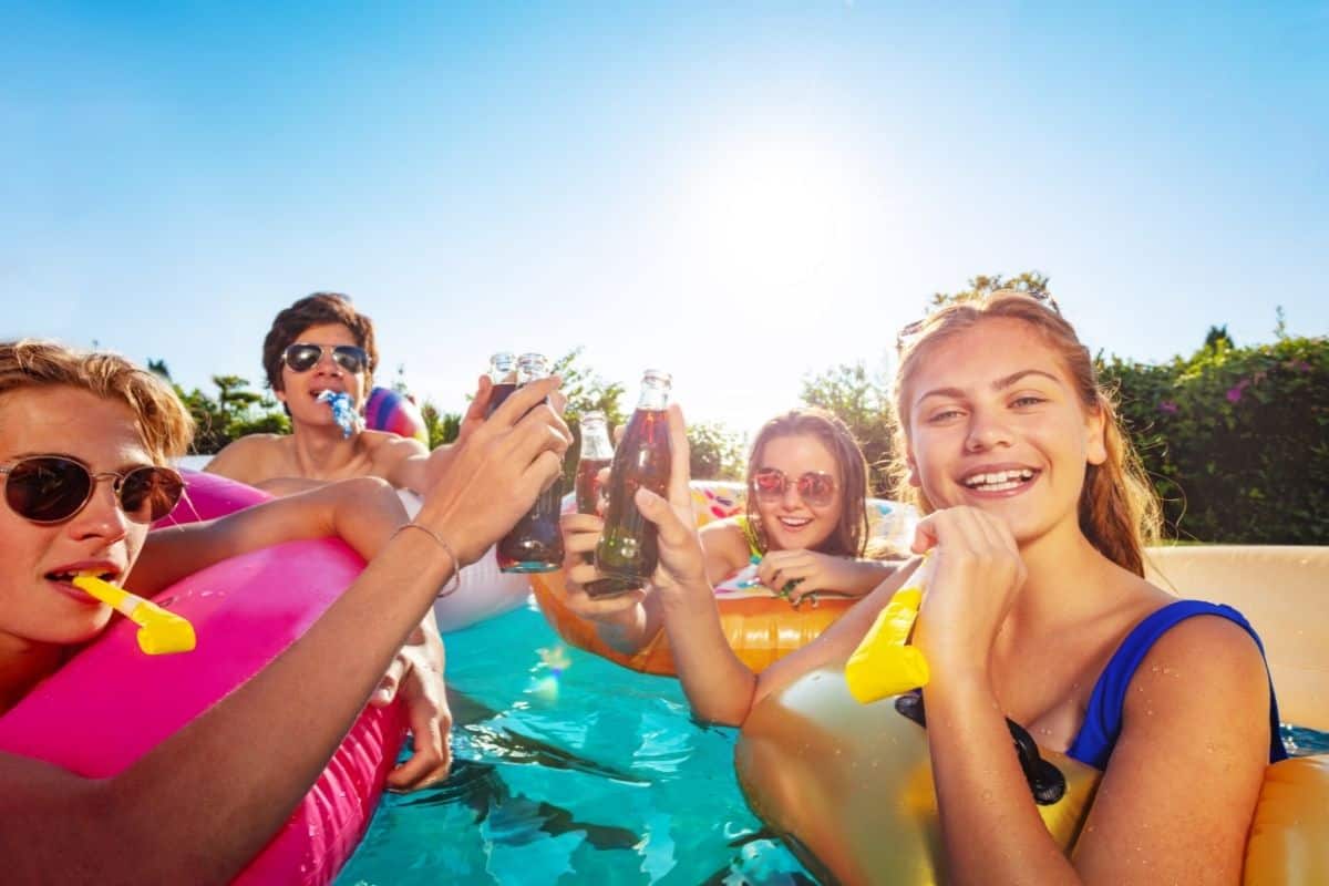 group of teens in the pool with floats