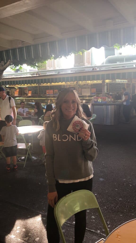 Kalee holding a Bob's doughnut in the Original Farmers Market