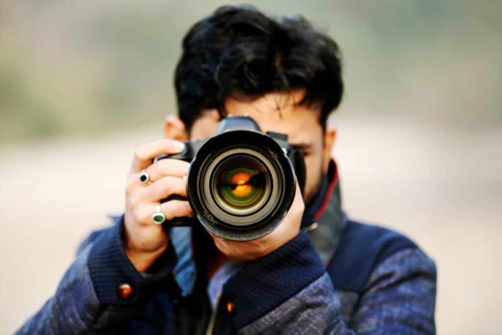 college kid on taking photos - you just see his face behind a large camera