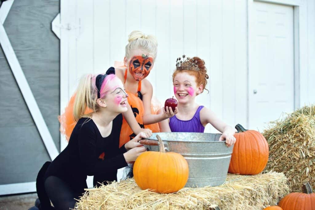 3 little girls bobbing for apples