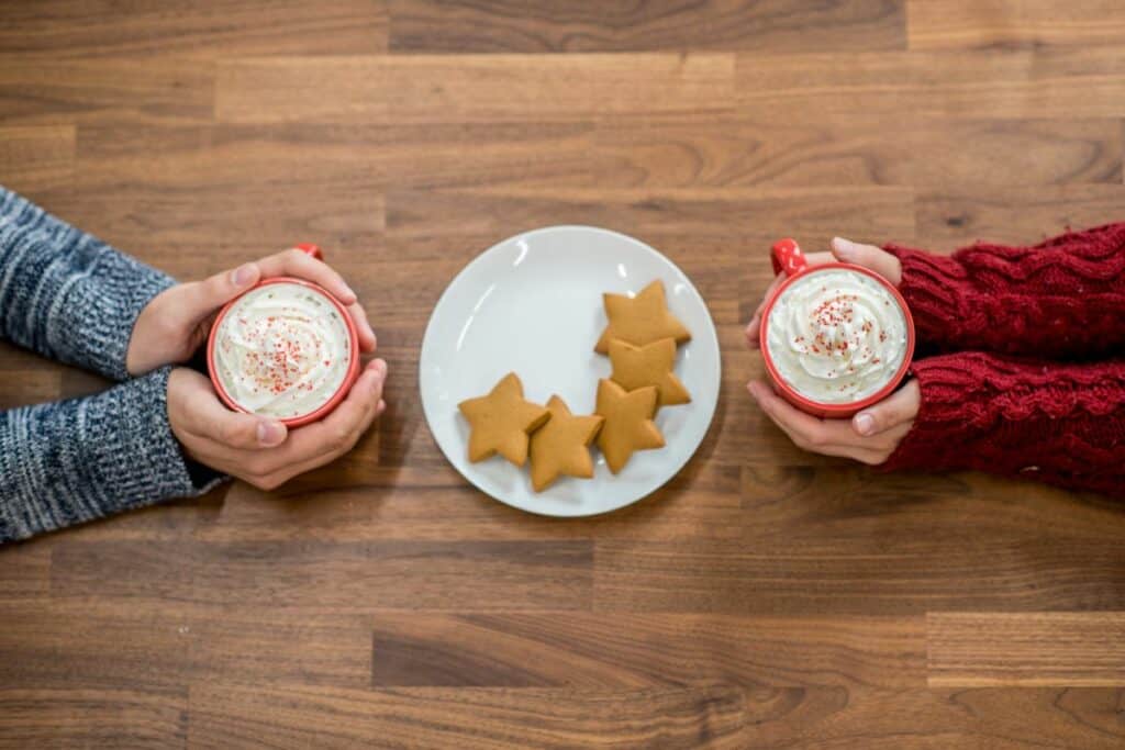 couple drinking coffee drinks with whipped cream and cookies