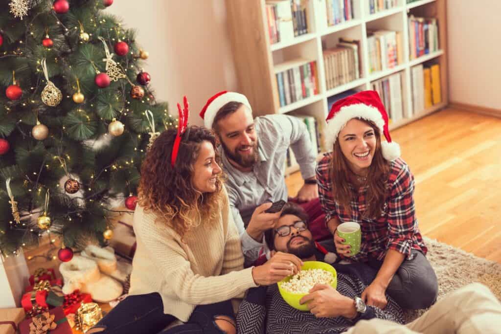 friends sitting together eating popcorn on Christmas