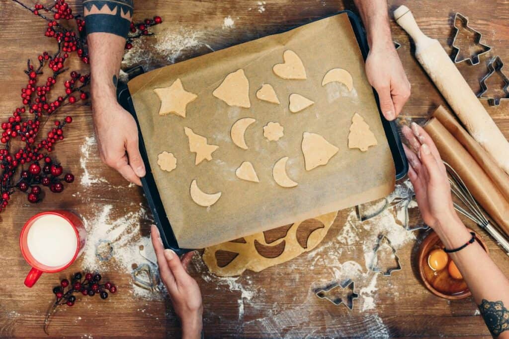 close up of hands and cookies on a cookie sheet