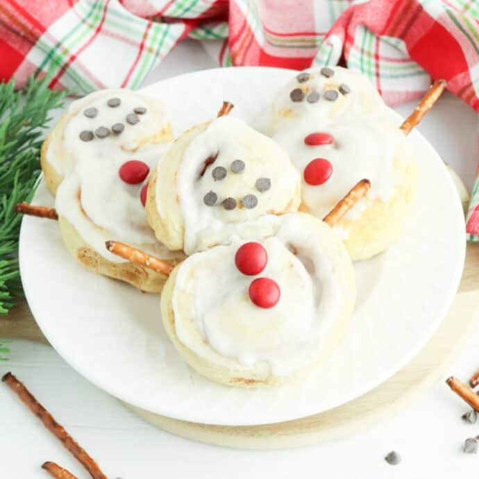 3 cinnamon roll snowmen on a plate