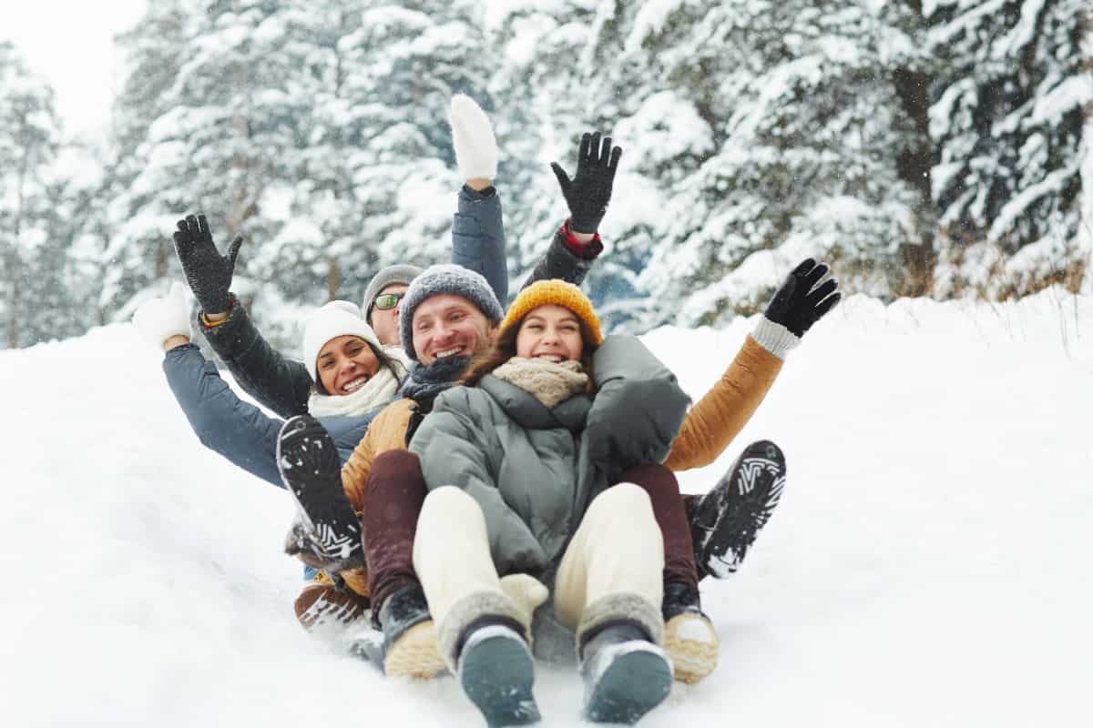 adult friends in the sledding together