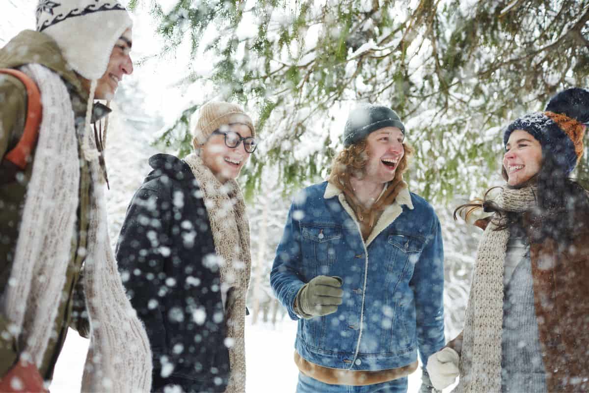 older kids in the snow together laughing