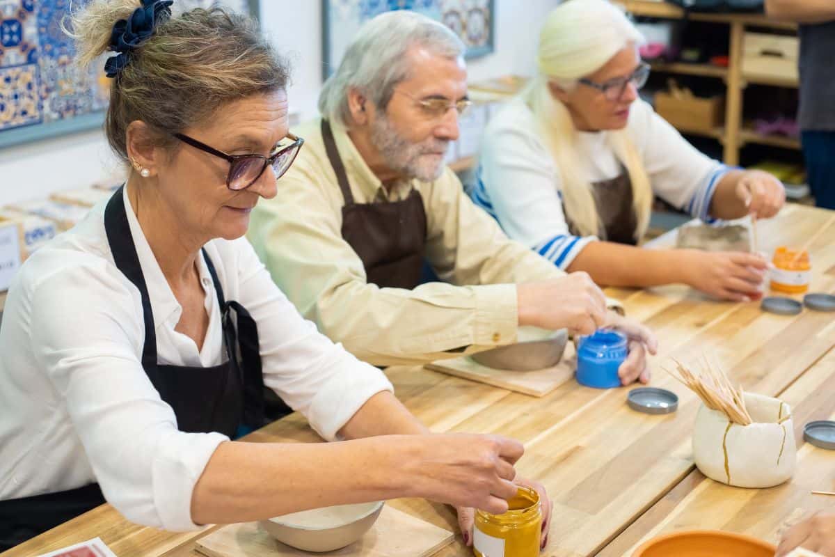 3 older people doing pottery