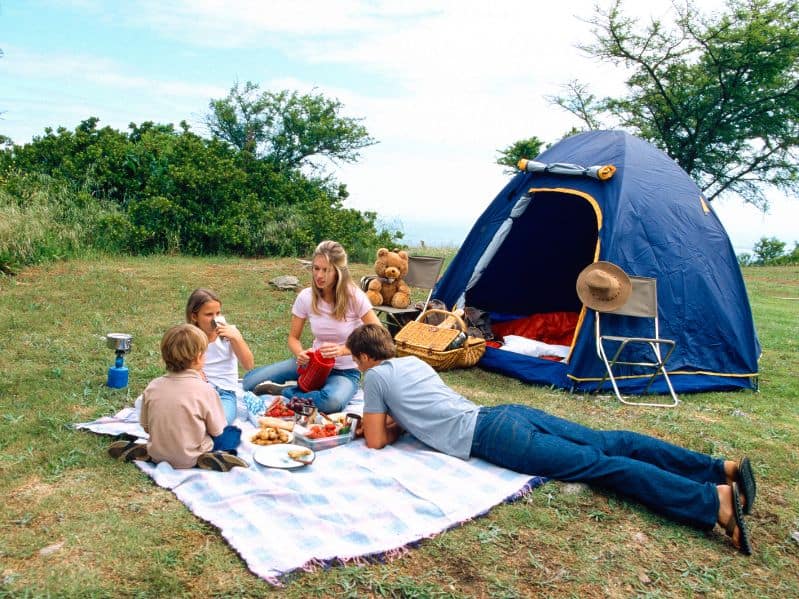 family of 4 camping during the day eating food