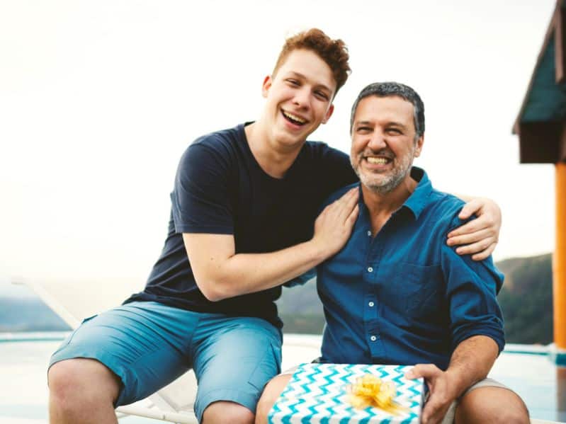 teenager side hugging his dad outside