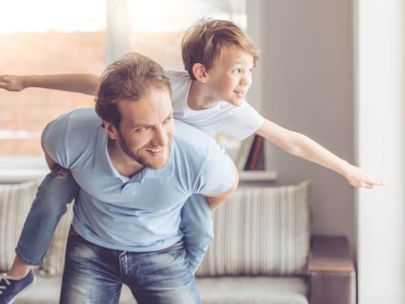 young dad with his young son on his back