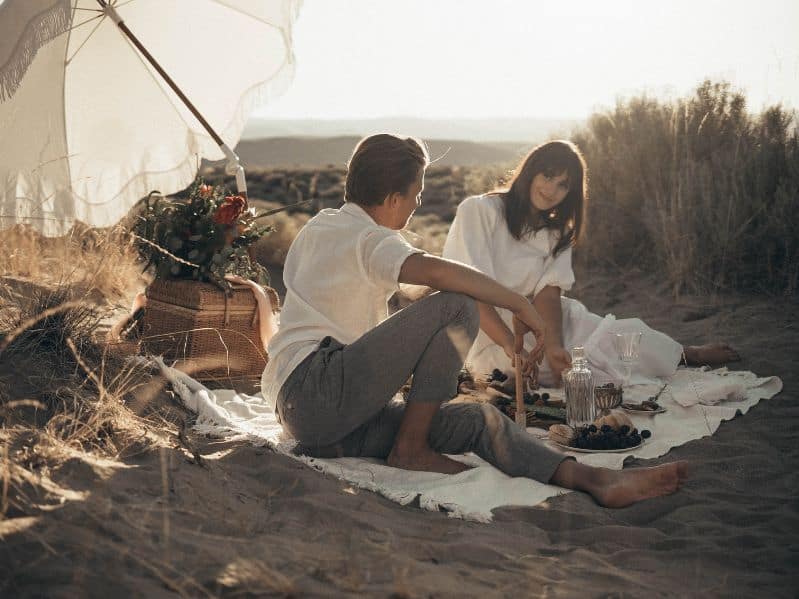 couple enjoying a picnic at the beach in the evening