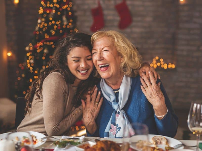 adult daughter at Christmas hugging her mom