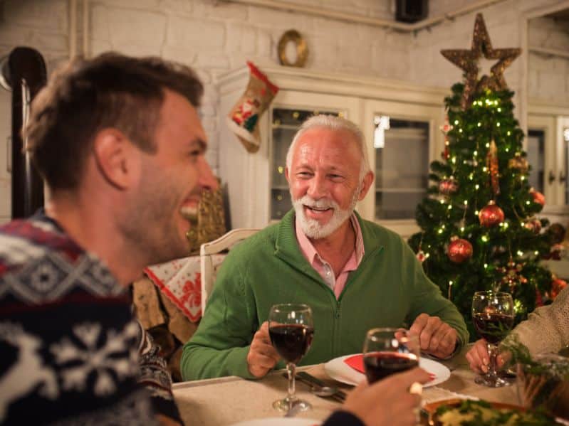 adult son at Christmas with his dad - both at a table