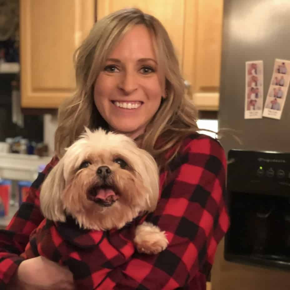 Kalee in Christmas pajamas with her pup in matching PJs