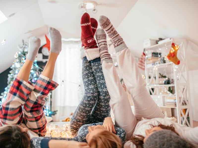 Christmas pajamas 3 people with their feet in the air