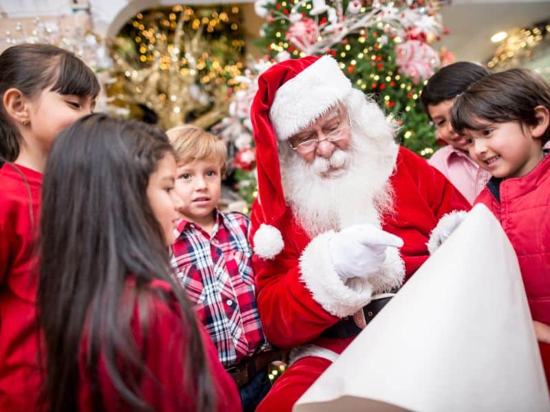 santa visting with kids looking at his list