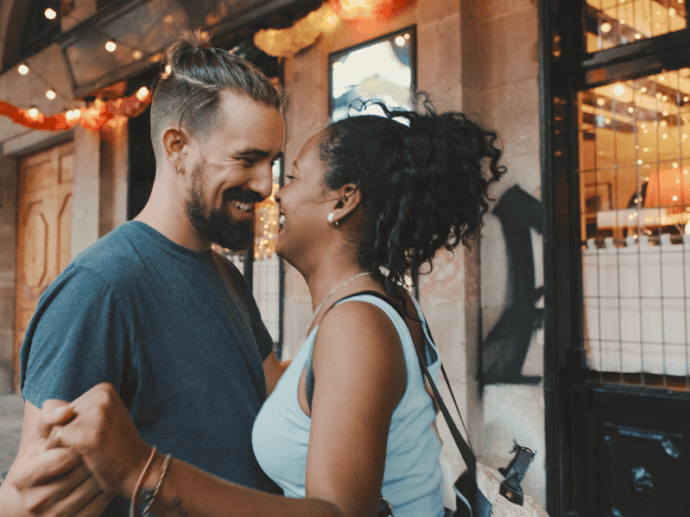 happy interracial couple outside a city shop