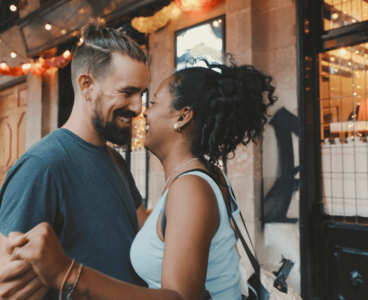 happy interracial couple outside a city shop
